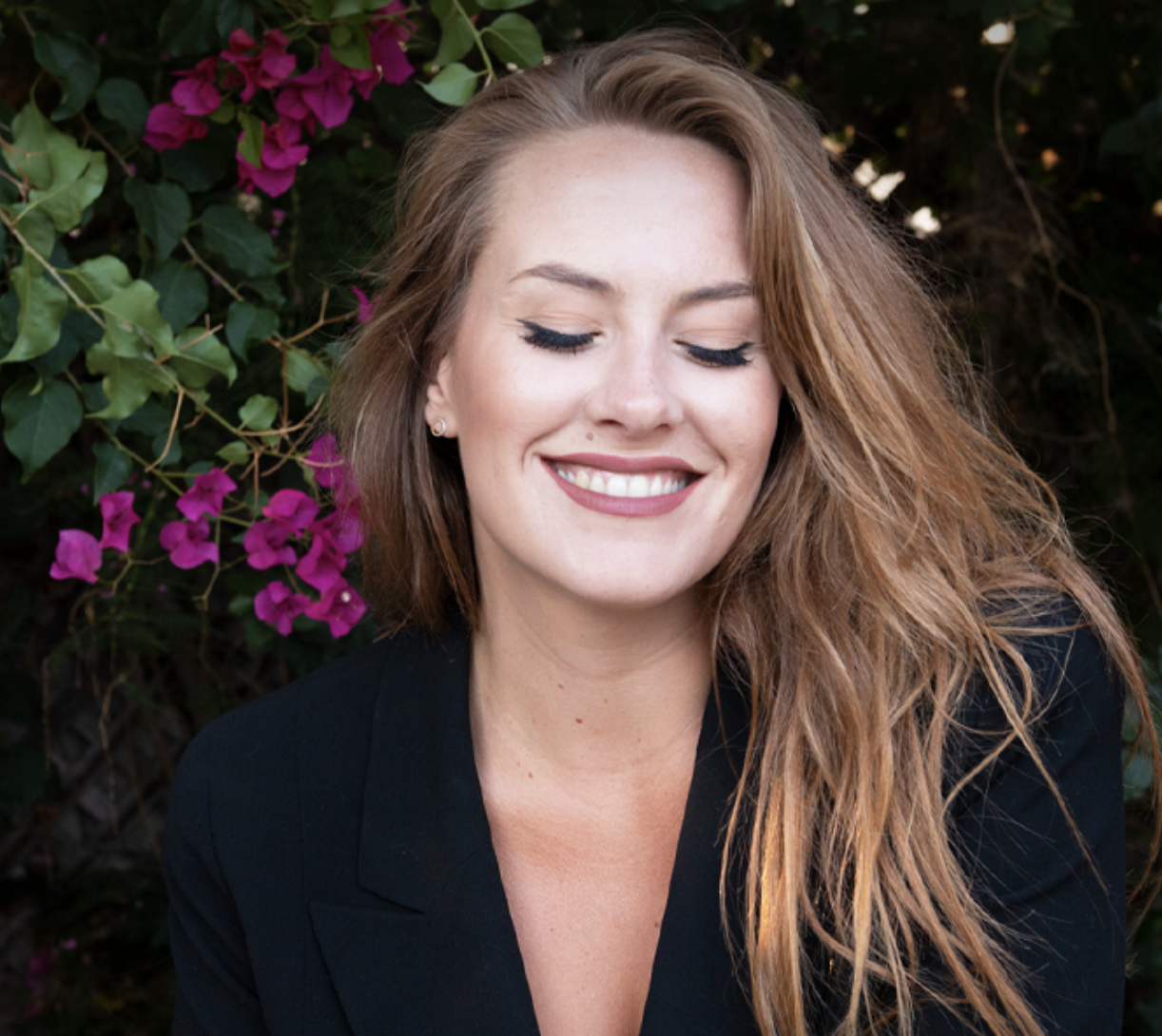 Photo of Mary Margaret Kunze, woman with long blond hair closing her eyes and smiling