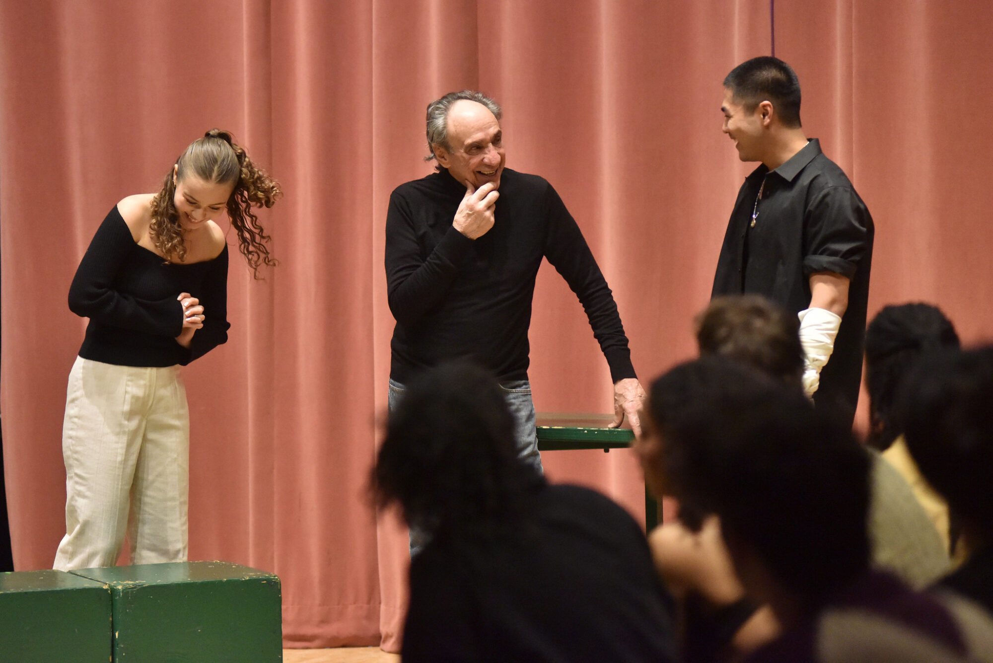 Two acting students, standing in front of a red curtain, work on a scene with working with Oscar-winning actor F. Murray Abraham.