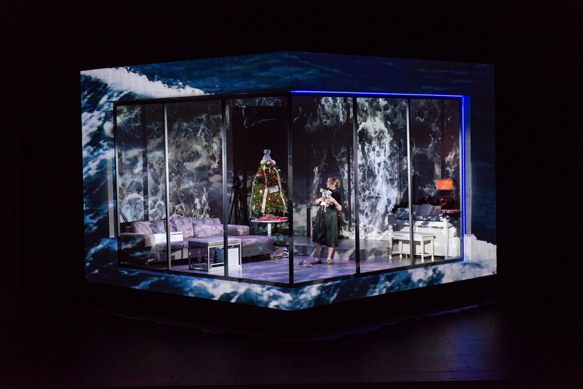 A photo showing a scene from the School of Drama’s production of “A Doll’s House,” with large waves projected onto the set.