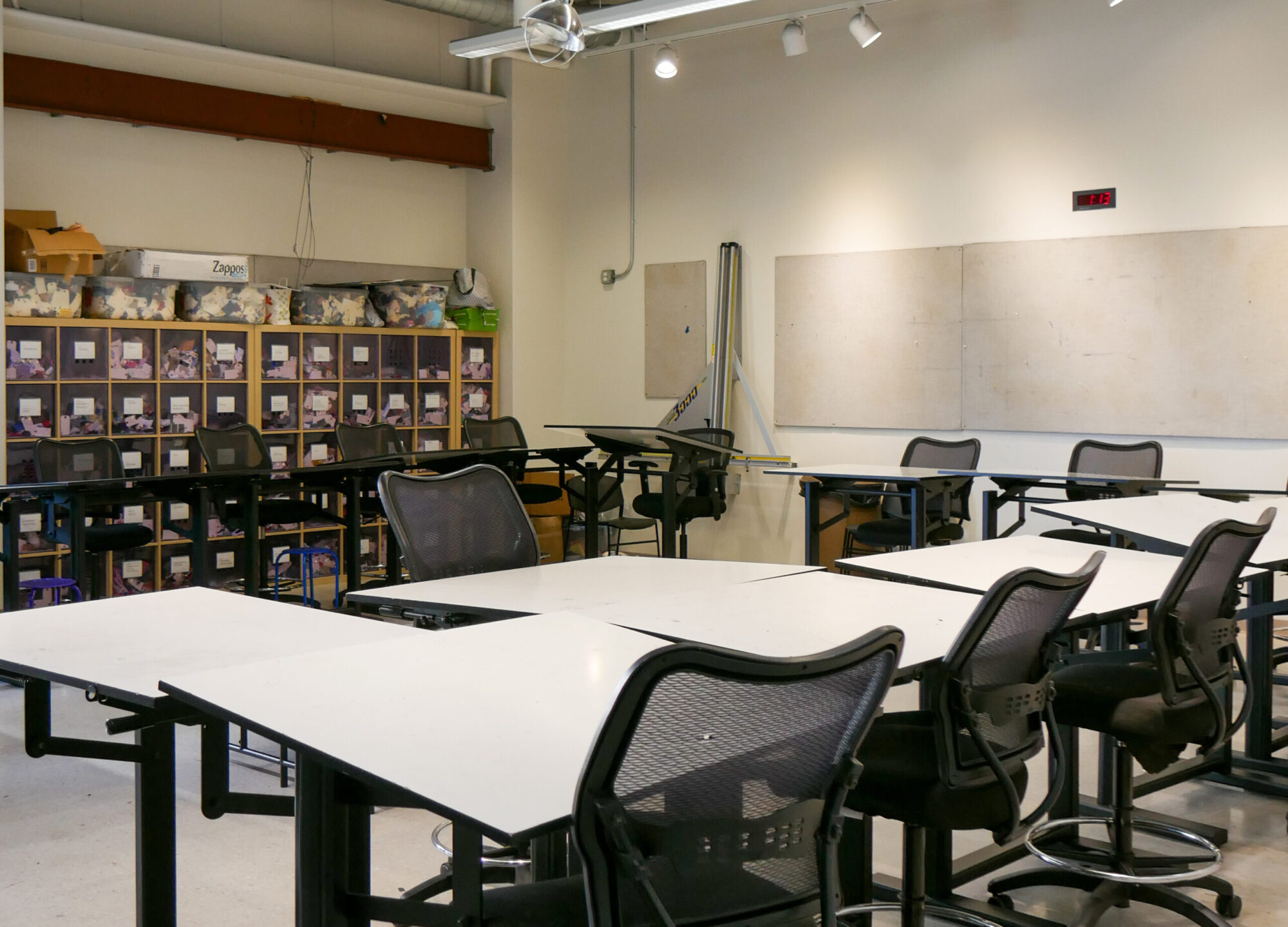 Interior photo of a design studio at Carnegie Mellon, with desks and chairs, and storage cubbies along the far wall.