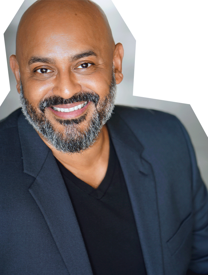 Photo of Robert Ramirez, a Mexican man with a bald head and dark, short beard, smiling, wearing a blazer and black shirt