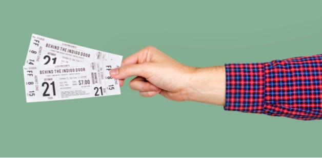 An arm outstretched, holding a pair of tickets to a performance.