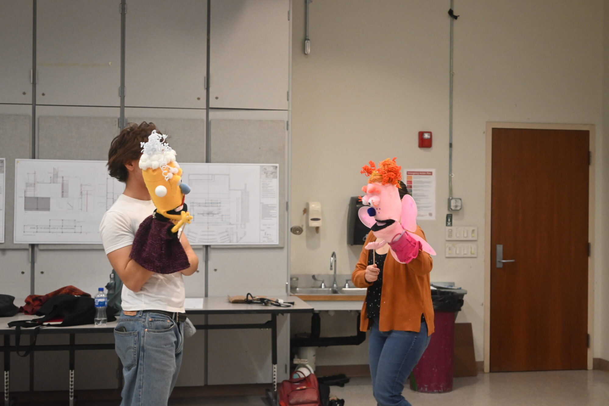 Two students holding puppets, in rehearsal for a Playground piece.