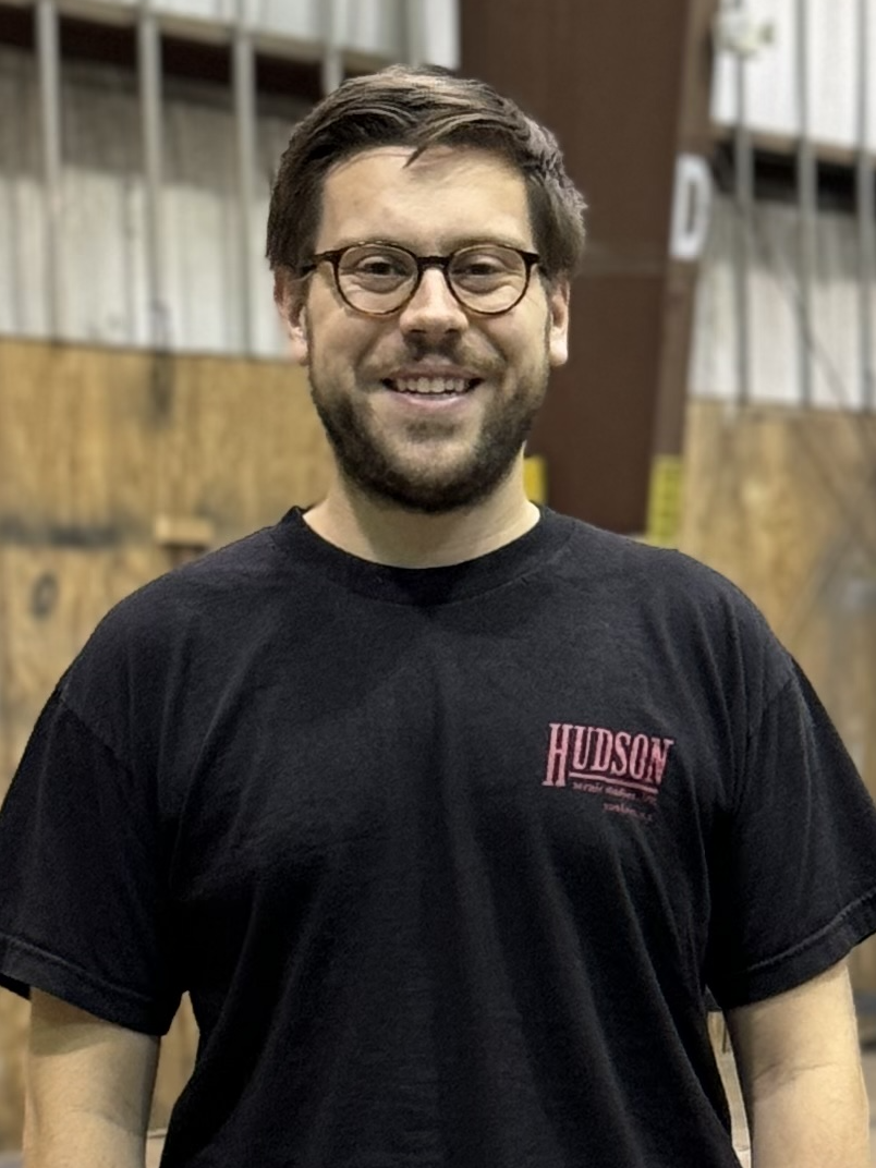 Photo of Ben King - a white man with light brown hair and beard, wearing glasses and a black t-shirt.