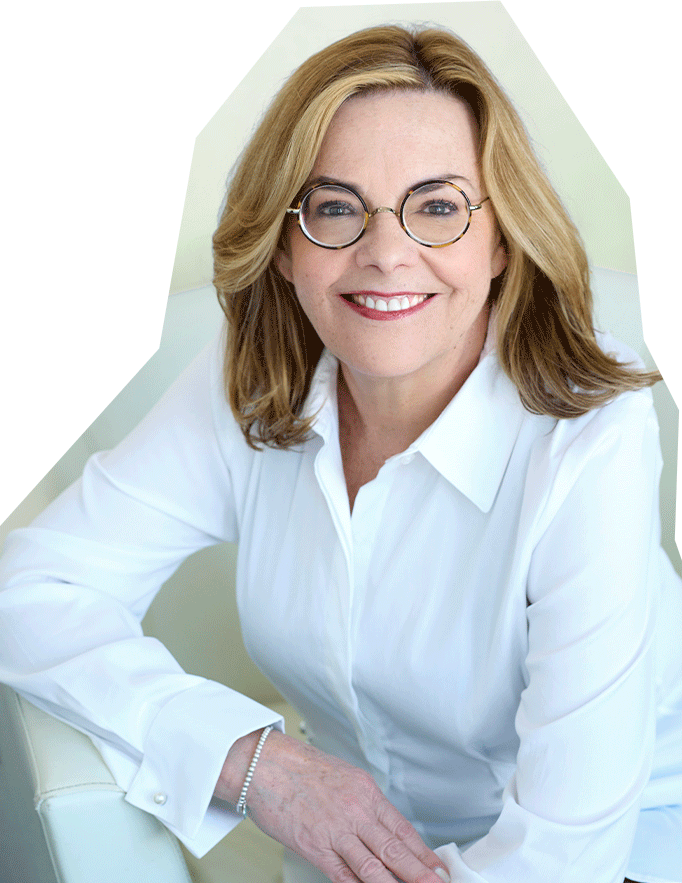 Photo of Claudia Benack, a white woman with medium length blonde hair and glasses, wearing a white collared blouse.