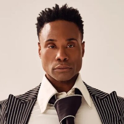 Photo of Billy Porter, a black man with short hair wearing a suit with an oversized tie.