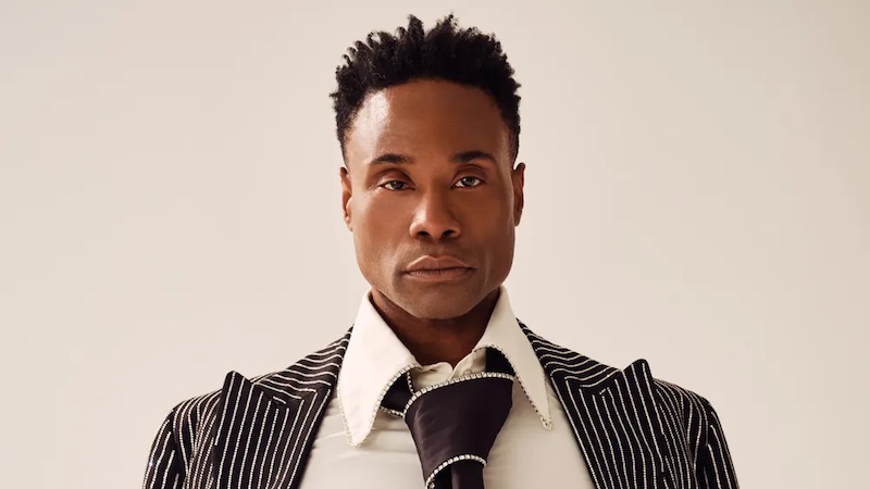 Photo of Billy Porter, a black man with short hair wearing a suit with an oversized tie.