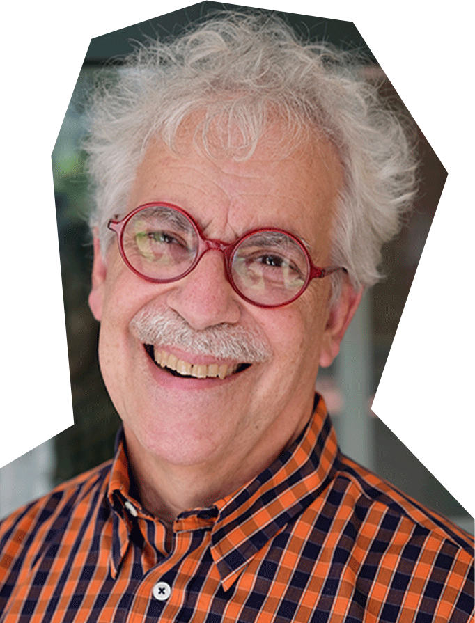 Photo of Dick Block, a white man with white hair and red framed glasses, wearing an orange and black checkered shirt.