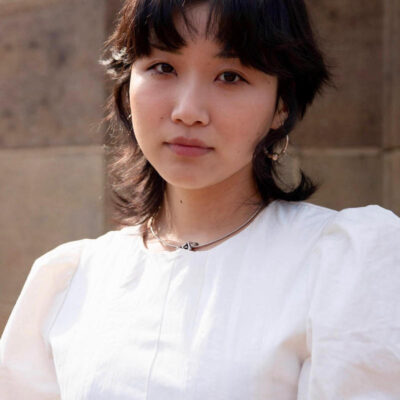 Photo of Davine Byon, a woman with short dark hair wearing a white blouse with puffy short sleeves.