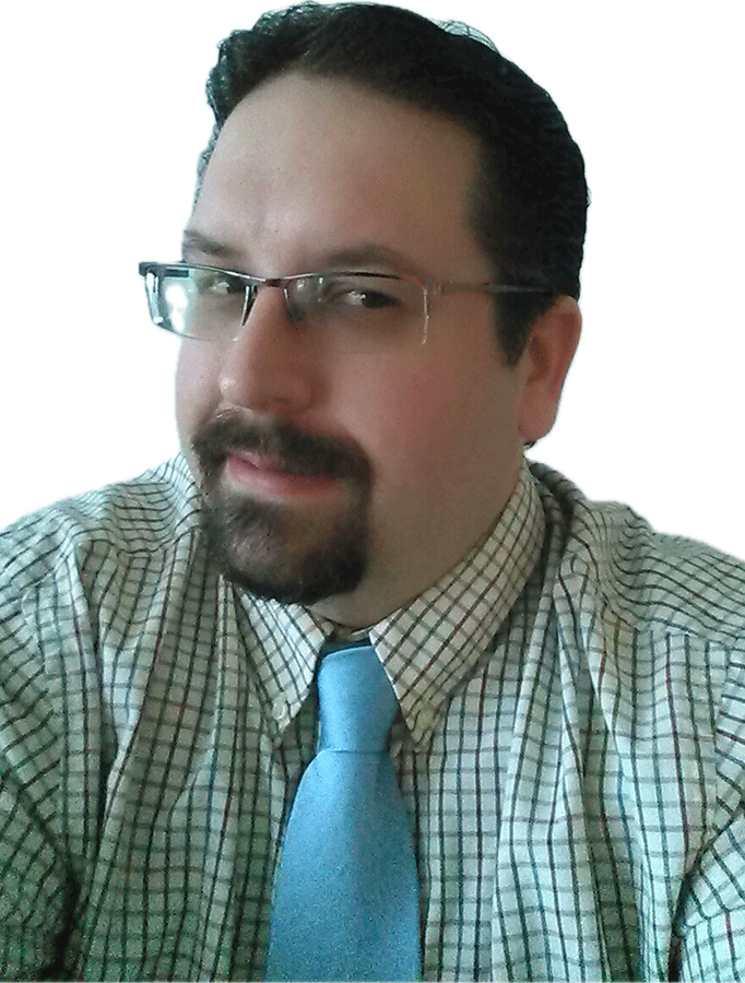 Photo of Todd Kulik, a white man with dark brown hair, glasses, and a goatee, wearing a green patterned button-up shirt and light blue tie.