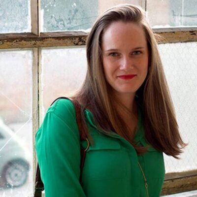 Photo of Rachel D'Amboise, a white woman with long brown hair, wearing a green blouse.