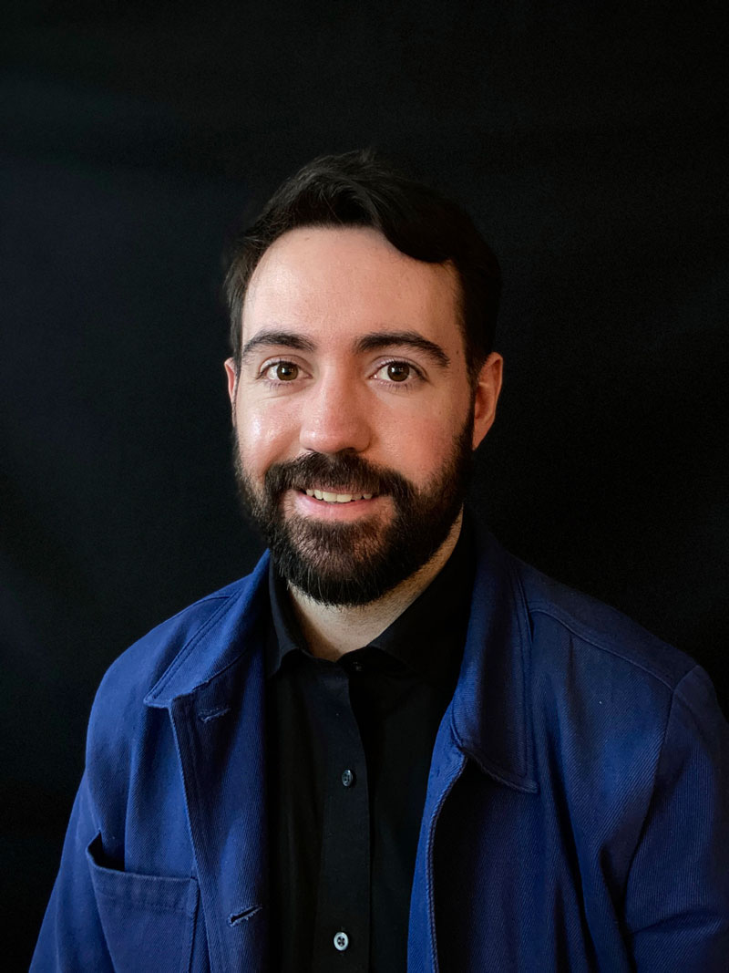 Photo of Sean Byrum Leo - a bearded man wearing blue dress shirt over a black t-shirt