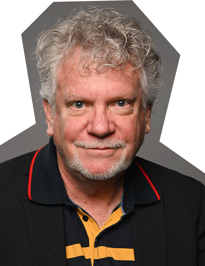 Photo of Robert Thomson, a white man with grey/white curly hair wearing a black collared shirt with red and yellow accents.