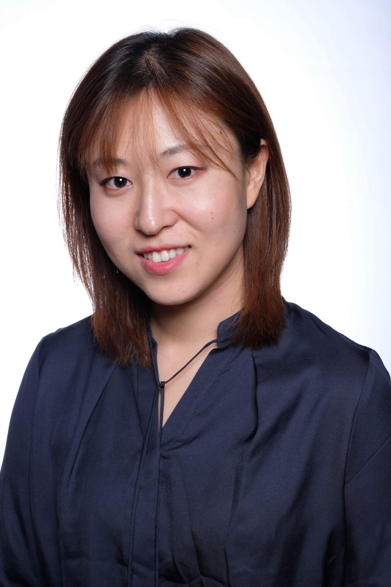 Photo of Vivienne Liu, an Asian woman with medium length brown hair, wearing a black blouse.