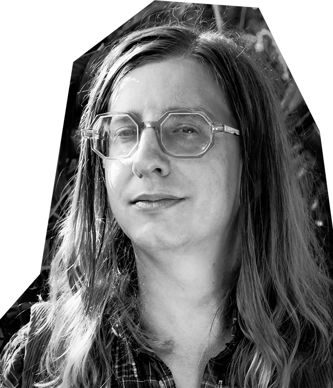 Black and white photo of Alex Young, a white person with long hair wearing tinted glasses.