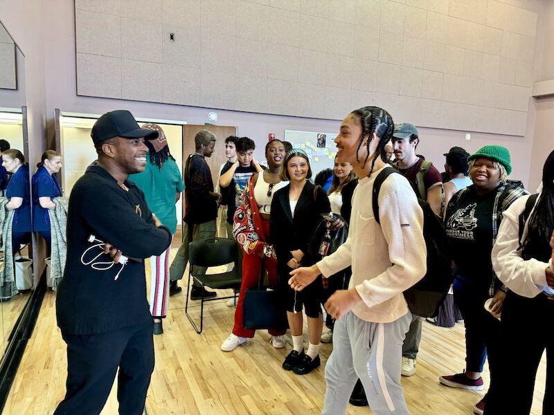 Leslie Odom, Jr. talks with a student in an acting classroom.