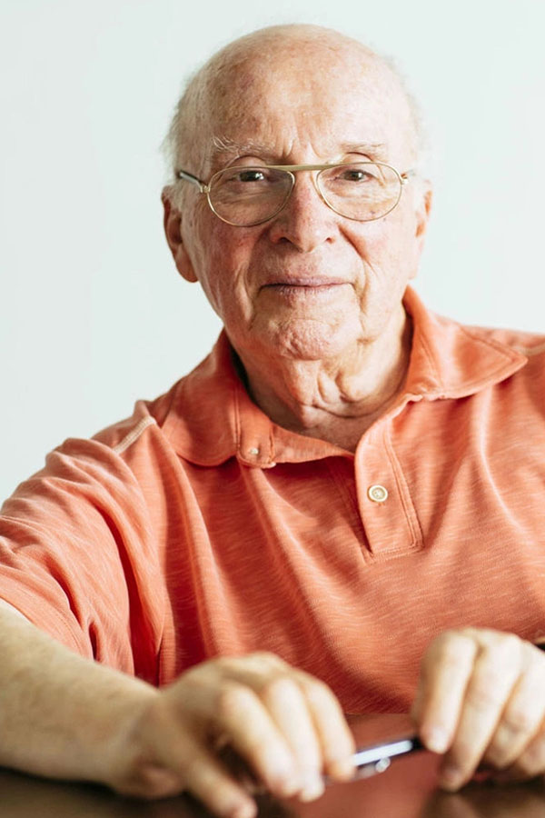 Photo of Mel Shapiro in a coral colored polo shirt