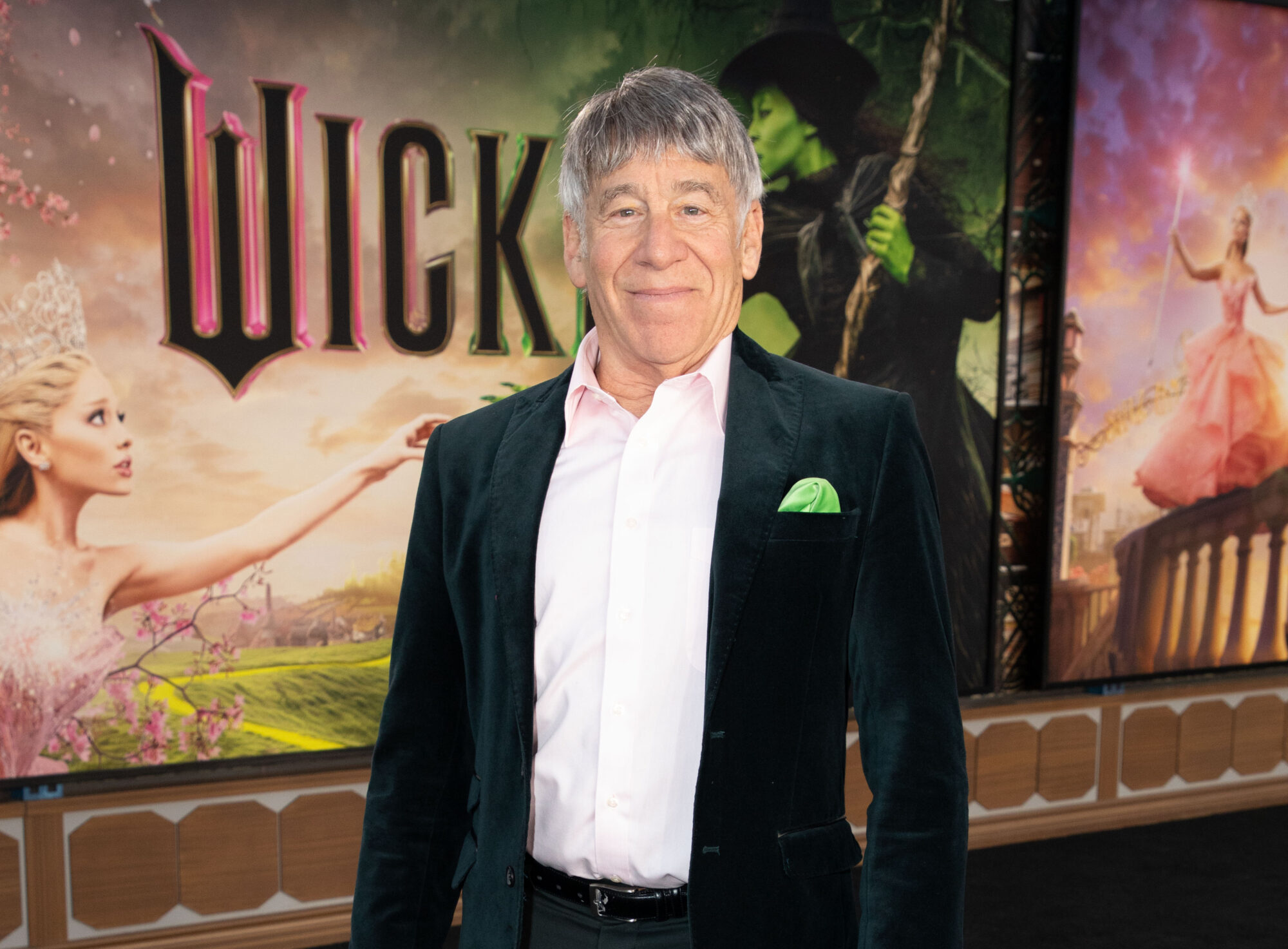 Stephen Schwartz stands in front of the "Wicked" movie poster on opening night.