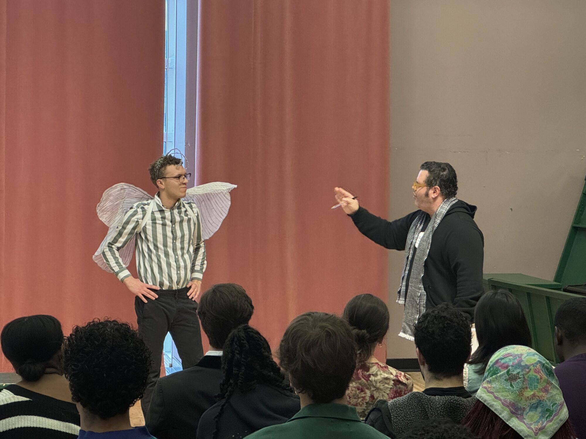 Josh Gad coaches a student wearing costume wings and antennae.