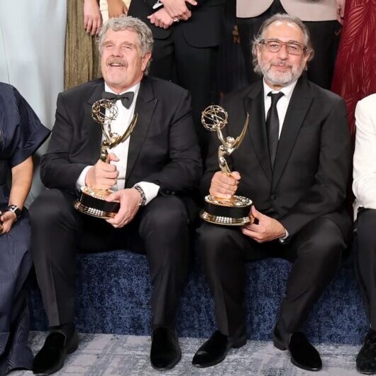 John Wells and Michael Hissrich pose with their Emmy Awards, 2026